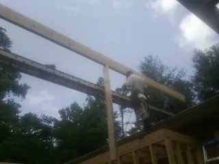 Carpenter setting a ridge beam over a new addition frame — Ice Dam Removal by Roofing Brothers in Charleroi