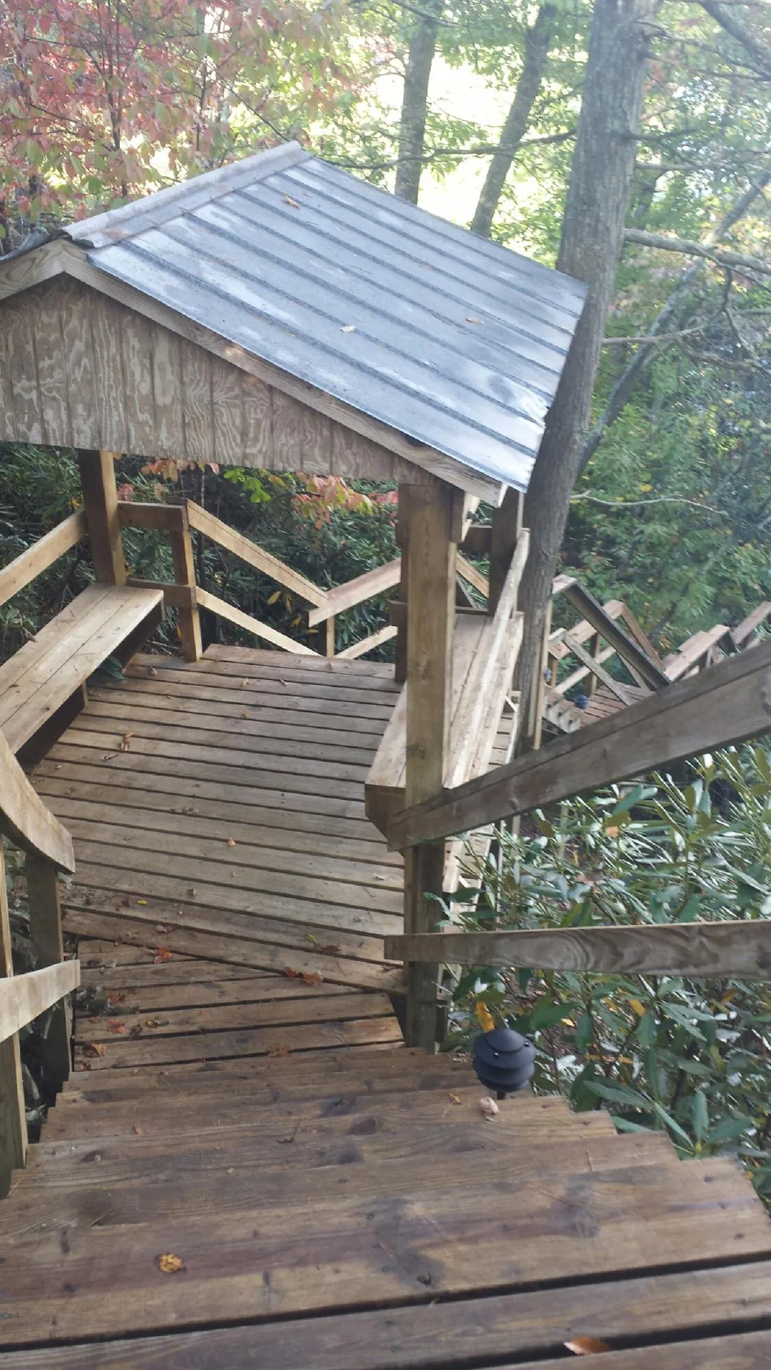 Metal roofed shelter over wooden steps on a wooded walkway — Skylight Repair & Installation work by our crew in Charleroi
