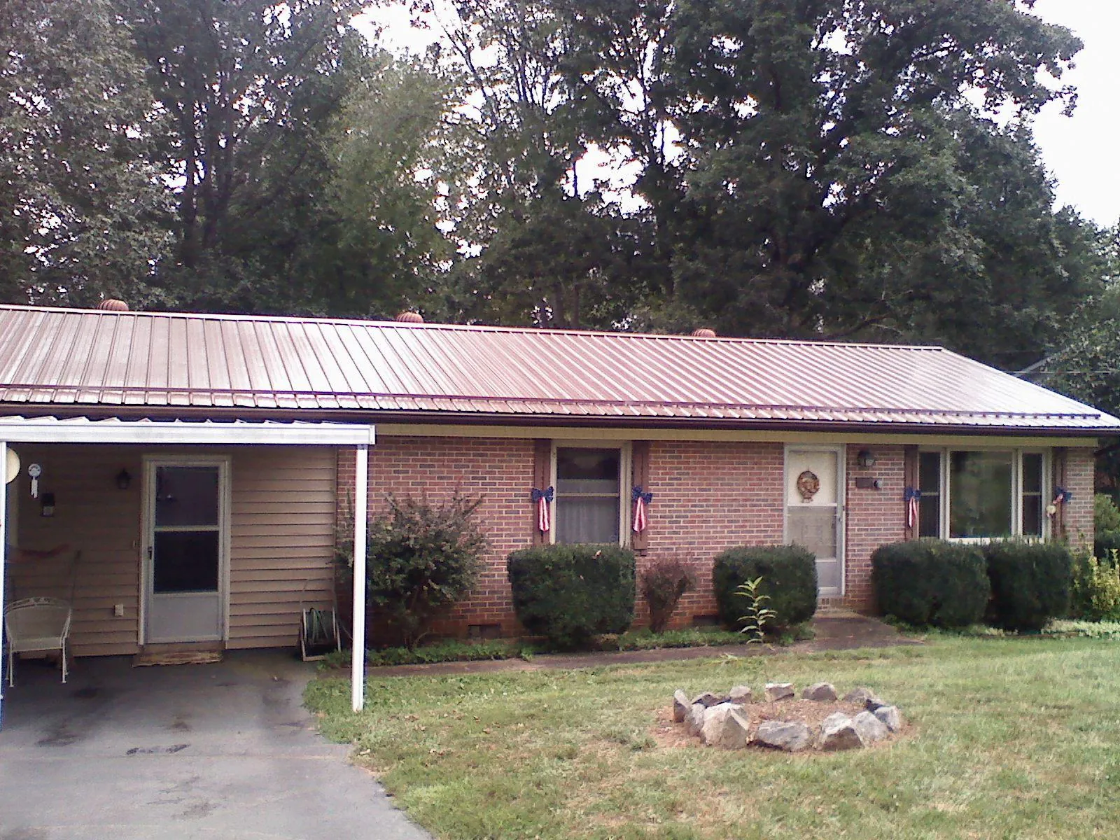 Bronze metal roof and carport on a brick ranch home — Roof Repair work by our crew in Charleroi